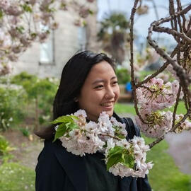 Girl with curly hair smiling, holding a violin